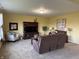 Cozy living room showcasing a comfortable brown reclining sofa, TV, and neutral carpet at 11958 Logan Hunter Trl, Noblesville, IN 46060