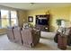Comfortable living room featuring a reclining sofa, large windows, entertainment center, and neutral carpet at 11958 Logan Hunter Trl, Noblesville, IN 46060