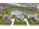 Aerial view of a brick home with a large pond, mature trees, and well-manicured lawn in a desirable community at 12030 Auburn Creek, Zionsville, IN 46077