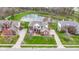 An aerial view of a beautiful brick home with lush green lawn and view of the surrounding pond at 12030 Auburn Creek, Zionsville, IN 46077