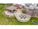 Aerial view of the outdoor living space featuring a stone patio with seating, a fire pit, and an outdoor kitchen at 12030 Auburn Creek, Zionsville, IN 46077