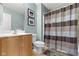 Neutral bathroom with a wooden vanity, framed art, and a shower featuring a striped curtain at 12030 Auburn Creek, Zionsville, IN 46077