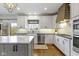 A spacious kitchen featuring white cabinets, stainless steel appliances, and a large island with marble countertops at 12030 Auburn Creek, Zionsville, IN 46077
