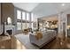 Open-concept living room features a fireplace, large windows, hardwood floors, and seamless flow to the kitchen at 12030 Auburn Creek, Zionsville, IN 46077