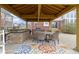 Covered outdoor kitchen with bar seating, a grill, and a dining table on a colorful rug at 12030 Auburn Creek, Zionsville, IN 46077