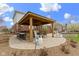 Outdoor kitchen with a covered area, stone bar with seating, and a fire pit at 12030 Auburn Creek, Zionsville, IN 46077