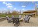 Outdoor space featuring fire pit with seating, covered kitchen, and mature trees in the background at 12030 Auburn Creek, Zionsville, IN 46077