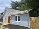 Side view of the home featuring blue vinyl siding, new cedar shake accents, and a fenced yard at 1308 W 18Th St, Indianapolis, IN 46202