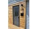 Close up of the front door with cedar accents, a wrought iron screen door, and the house number at 1308 W 18Th St, Indianapolis, IN 46202