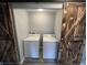 Functional laundry room featuring a washer and dryer, enclosed by rustic barn doors for added charm at 1308 W 18Th St, Indianapolis, IN 46202