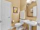 Clean half bathroom featuring pedestal sink, toilet, mirror and decorative artwork at 13214 Mink Ln, Carmel, IN 46074