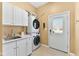 Functional laundry room with stackable washer/dryer and storage cabinets at 13214 Mink Ln, Carmel, IN 46074
