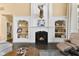 Cozy living room showcasing a fireplace, built-in shelves, and hardwood floors at 13214 Mink Ln, Carmel, IN 46074