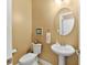 Quaint powder room with pedestal sink, toilet, and decorative mirror at 13214 Mink Ln, Carmel, IN 46074