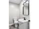 Bathroom with a white sink and vanity, toilet, and a black framed mirror and lighting fixture at 1331 W 33Rd St, Indianapolis, IN 46208