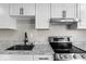 Modern kitchen featuring sleek white cabinets, gray countertops, stainless steel appliances, and laminate flooring at 1331 W 33Rd St, Indianapolis, IN 46208