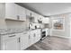 Modern kitchen featuring sleek white cabinets, gray countertops, stainless steel appliances, and laminate flooring at 1331 W 33Rd St, Indianapolis, IN 46208