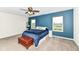 Charming bedroom with blue accent wall, carpeted floors, and a window overlooking a scenic view at 1455 Bigleaf Dr, Sheridan, IN 46069