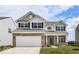 Charming two-story home with a brick and siding exterior, attached two-car garage, and a well-manicured front yard at 1455 Bigleaf Dr, Sheridan, IN 46069