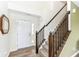 Bright foyer with wood laminate flooring, staircase with dark wood railing, and white front door at 1455 Bigleaf Dr, Sheridan, IN 46069