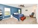 Comfortable main bedroom featuring carpet flooring, a ceiling fan, two windows, and a relaxing rocking chair at 1455 Bigleaf Dr, Sheridan, IN 46069