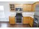 Modern kitchen featuring stainless steel appliances, wooden cabinets, and ample counter space at 15398 Border Dr, Noblesville, IN 46060