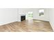 Bright living room with wood-look floors, a modern fireplace, and sliding glass doors leading outside at 159 Derringer Ave, Westfield, IN 46074