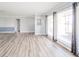 Open living room featuring hardwood floors, large windows, and light gray walls at 1611 Orchard Ln, Anderson, IN 46011