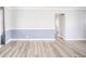 Open living room featuring hardwood floors, a blue accent wall, and a view of the hallway at 1611 Orchard Ln, Anderson, IN 46011