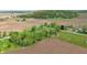 Scenic aerial shot features a charming property with a blend of greenery and adjacent cultivated farmland at 1901 S Old State Road 67, Paragon, IN 46166