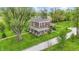 Aerial view of a brick two-story home surrounded by lush greenery and mature trees at 1901 S Old State Road 67, Paragon, IN 46166
