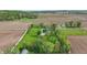 Aerial perspective of a quaint home nestled amidst green lawns, complemented by trees and neighboring agricultural fields at 1901 S Old State Road 67, Paragon, IN 46166