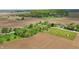 High-angle shot captures a serene property next to farmlands, highlighted by lush trees and meticulously kept grounds at 1901 S Old State Road 67, Paragon, IN 46166