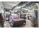 Basement bedroom featuring exposed ceiling pipes, painted brick walls, and built-in shelving for ample storage at 1901 S Old State Road 67, Paragon, IN 46166