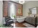 Luxurious bathroom with standalone tub, brick accent wall, and modern vanity at 1901 S Old State Road 67, Paragon, IN 46166