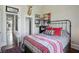 Bedroom with queen bed, decorative bedding, and doorway to hallway with patterned wood floors at 1901 S Old State Road 67, Paragon, IN 46166