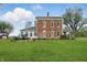 Classic brick home featuring a sunroom, patio, and expansive green lawn at 1901 S Old State Road 67, Paragon, IN 46166