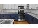 Updated kitchen showcases granite countertops, stainless steel appliances, and stylish white and navy cabinetry at 270 W Broadway St, Shelbyville, IN 46176