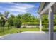Backyard pond view from covered patio with mature trees and lush landscaping at 2736 Victory Dr, Columbus, IN 47203