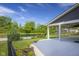 Backyard and covered patio with view to pond surrounded by mature trees at 2736 Victory Dr, Columbus, IN 47203