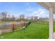 Serene backyard view featuring a lush lawn, a tranquil pond, and a black fence, offering privacy and beauty at 2736 Victory Dr, Columbus, IN 47203