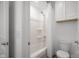 Clean bathroom with a shower-tub combo, white tile, and functional storage at 2736 Victory Dr, Columbus, IN 47203