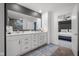 Bathroom featuring a dual sink vanity, framed mirror, contemporary fixtures, and wood flooring at 2736 Victory Dr, Columbus, IN 47203
