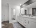 The bathroom features a dual sink vanity with white countertops, modern fixtures, and wood flooring at 2736 Victory Dr, Columbus, IN 47203