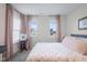 Bright bedroom with two windows, complemented by stylish pink curtains and a flower-patterned comforter at 2736 Victory Dr, Columbus, IN 47203