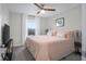Comfortable bedroom showcasing a ceiling fan, natural light, and a view to the outdoors at 2736 Victory Dr, Columbus, IN 47203