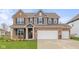 Charming two-story brick home featuring a two-car garage and a well-manicured lawn and tasteful landscaping at 2736 Victory Dr, Columbus, IN 47203