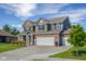 Beautiful two-story home showcasing brick and gray siding, a well-manicured lawn, and an attached three-car garage at 2736 Victory Dr, Columbus, IN 47203