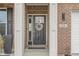 Close-up of a home's black front door framed by white trim, showcasing a decorative wreath and brick surround at 2736 Victory Dr, Columbus, IN 47203