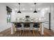 Kitchen island featuring white cabinets, black countertop, and pendant lights at 2736 Victory Dr, Columbus, IN 47203